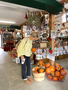 a woman standing in front of baskets filled with oranges