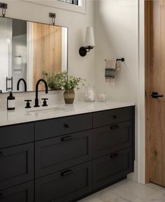 a bathroom with two sinks and a large mirror on the wall next to an open door