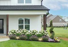 a white house with flowers in the front yard