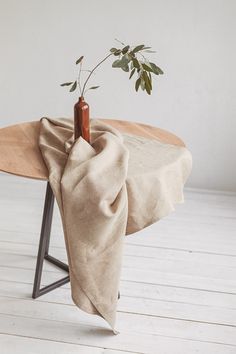 a table with a cloth draped over it and a small plant on top of it