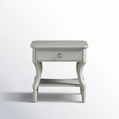 a small white table with one drawer on the top and two drawers on the bottom