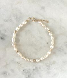 This  pearl bracelet is a beautiful staple piece!  Handmde with genuine freshwater pearls and little 14k gold filled accent beads. Perfect for your everyday and special looks! Please understand that every pearl is unique, and may resemble a different shape and size from the pearls in our photo!  - Each pearl measures 4-5mm. - Gold filled beads measure 3mm - Will not tarnish - Size up and wear as an anklet All of our jewelry is handmade with love in Nova Scotia, Canada. METALS Our jewelry is made 14k Gold Filled Pearl Bracelet With Round Beads, 14k Gold-filled Pearl Bracelet With Round Beads, White Beaded Pearl Bracelet 14k Gold Filled, White Beaded Pearl Bracelet With 14k Gold Filling, White Beaded Pearl Bracelet In 14k Gold Filled, White Beaded Pearl Bracelet In 14k Gold, 14k Gold Filled White Pearl Drop Bracelets, White 14k Gold Filled Pearl Drop Bracelets, White 14k Gold-filled Pearl Drop Bracelets