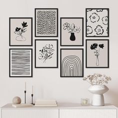 a white dresser sitting next to a wall filled with pictures and vases on top of it