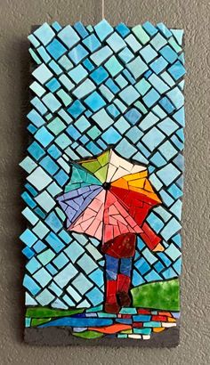 a colorful mosaic art piece with an umbrella in the rain on it's side