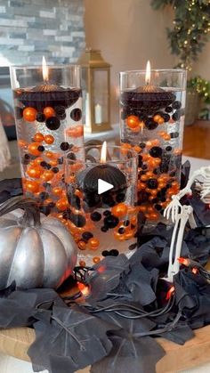 three candles are sitting on a table with black and orange decorations