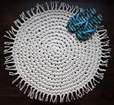 a white and blue placemat on a wooden table with a blue bow laying on it