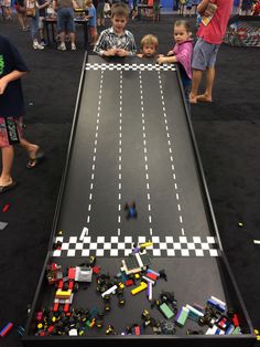 children playing with legos on an indoor race track