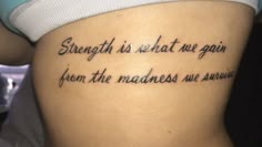 a woman with a tattoo saying strength is what we gain from the machines we win