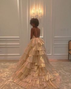 a woman standing in front of a white wall wearing a dress made out of paper