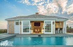 a house with a pool in front of it and a covered patio next to it