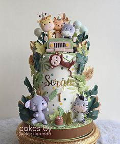 a three tiered cake decorated with animals and trees