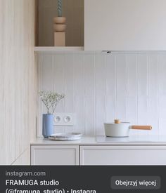 a kitchen with white cabinets and wooden shelves