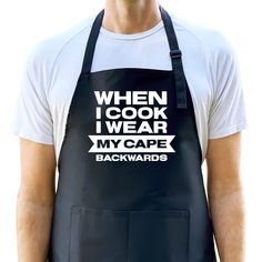 a man wearing an apron that says when i cook i wear my cape backwardss