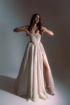 a woman in a white dress is posing for the camera with her legs spread out