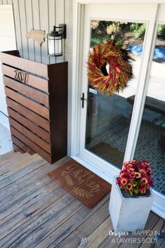 the front porch is decorated with fall wreaths