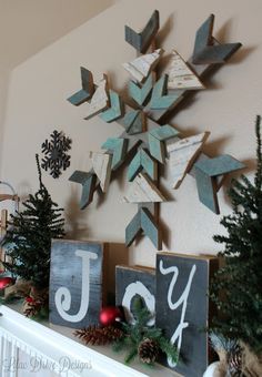 a mantel decorated with christmas decorations and wooden blocks that say joy, joy, and snowflakes