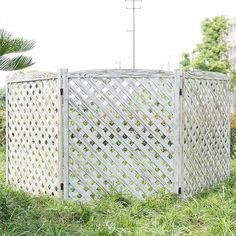 a white fence sitting in the middle of a lush green field