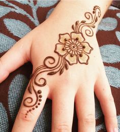 a woman's hand with henna tattoos on it