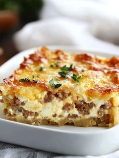 a close up of a casserole dish on a plate with cheese and meat