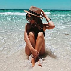 a woman sitting in the water at the beach