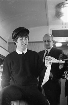 two men standing next to each other holding papers