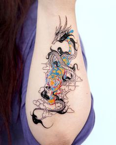 a woman's arm with a dragon tattoo on the left side of her body