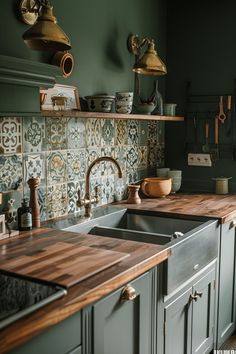 a kitchen with green walls and wooden counter tops, an old fashioned faucet hangs above the sink