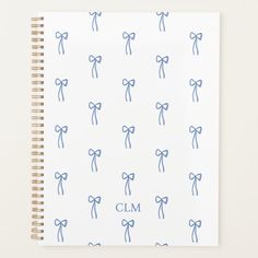 a spiral notebook with blue bows and the word clm written on it in cursive writing