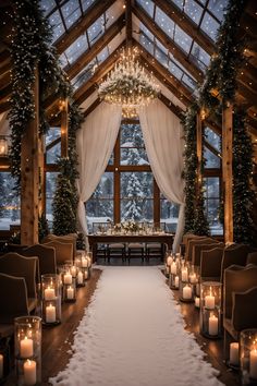 an indoor wedding venue with candles lit up in the aisle and snow on the ground