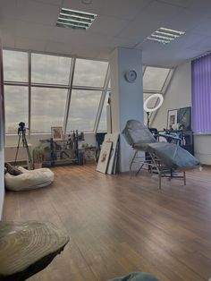 an empty room with lots of windows and furniture on the floor, including a chair