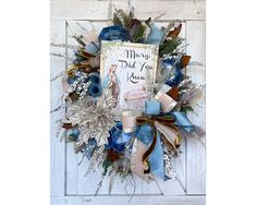 a blue and white wreath with a card saying merry dad you are here