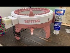 a pink and white contraption sitting on top of a wooden table