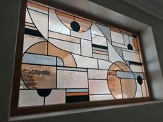 a close up of a stained glass window in a room with white walls and brown trim