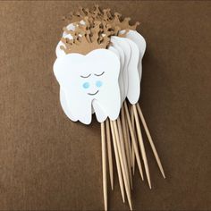 tooth with crown on it sitting on top of wooden sticks