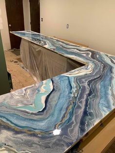 a counter top that has been painted with blue and white marbled designs on it