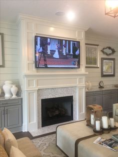 a living room filled with furniture and a flat screen tv mounted above a fire place