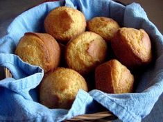 a basket filled with muffins sitting on top of a blue cloth covered table