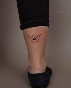 a woman's foot with a small tattoo on her left leg and the word love written in cursive writing