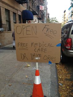 a sign that has been placed on the side of a road in front of a building