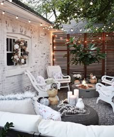 an outdoor living room with white furniture and string lights