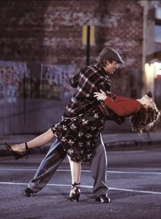 a man and woman dancing on the street