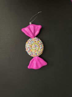 a pair of pink earrings with sprinkles on them