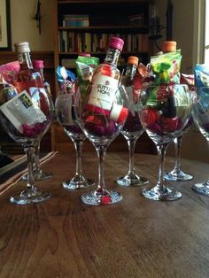 several wine glasses filled with different types of candy and candies on a wooden table