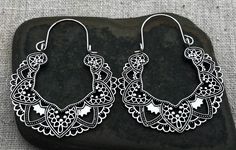 Silver cut out filigree hoop earrings. They are eye catching and versatile. Dress them up or down. Perfect for everyday wear. The hoops measure about 2" long by 1 5/8" wide. Made from plated silver. Thanks for stopping by! Please take a moment and visit the rest of my Etsy shop. I have many more unique jewelry designs to choose from! Tiger Flower Jewelry Black Bohemian Hoop Earrings For Festivals, White Hoop Earrings For Festival, White Teardrop Bohemian Hoop Earrings, Bohemian Black Nickel-free Hoop Earrings, Bohemian Nickel-free Black Hoop Earrings, Bohemian White Teardrop Hoop Earrings, Bohemian Hypoallergenic Hoop Earrings For Festivals, Bohemian White Pierced Hoop Earrings, White Bohemian Pierced Hoop Earrings