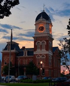 a large building with a clock on the front and side of it's tower