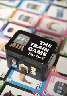 the train game is sitting on top of some cards that are all different colors and shapes