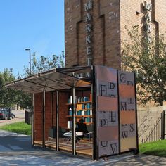 a book store on the side of a street in front of a tall brick building