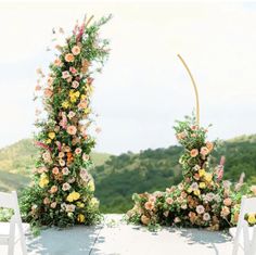 an outdoor ceremony setup with flowers and greenery