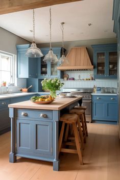 a kitchen with blue cabinets and island in the center, surrounded by stools that sit on hard wood flooring