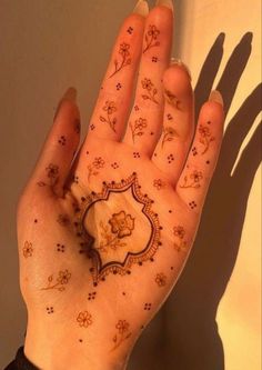 a woman's hand with henna tattoos on it